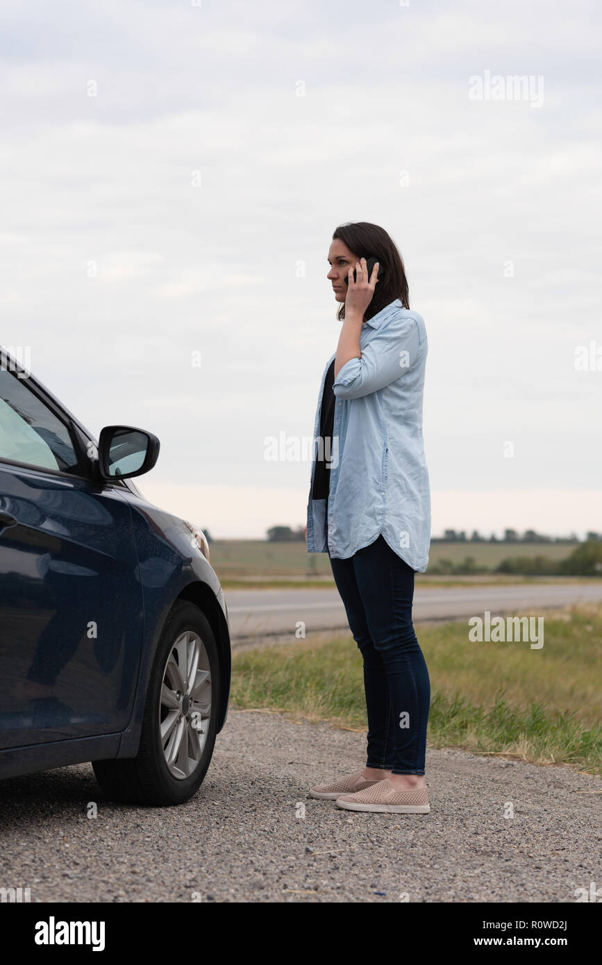 Frau Gespräch am Handy während Autopanne Stockfoto