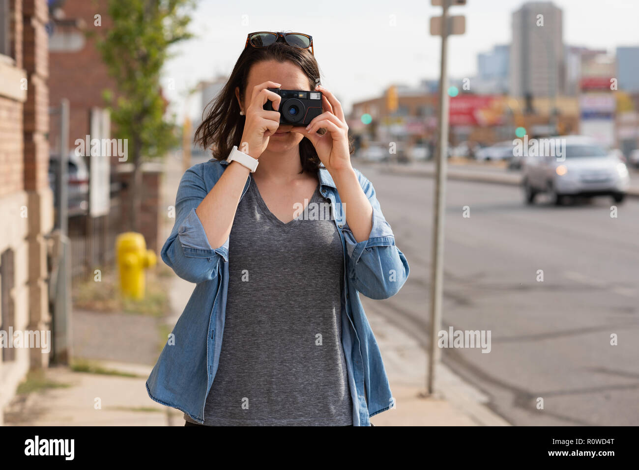 Frau Fotos klicken Sie mit der Kamera in der Stadt Stockfoto