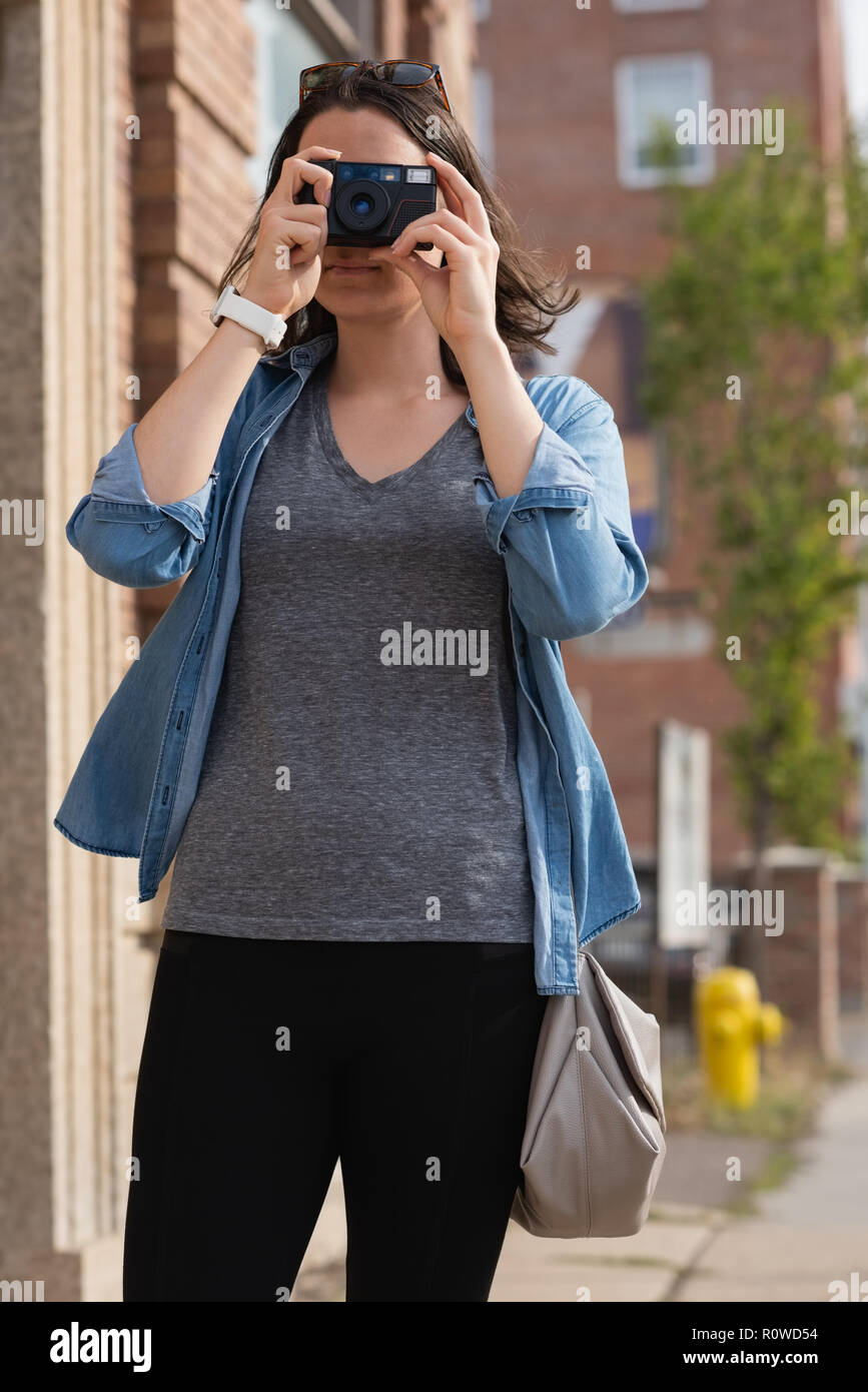 Frau Fotos klicken Sie mit der Kamera in der Stadt Stockfoto