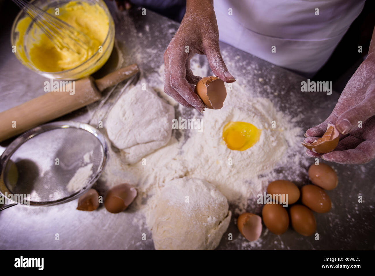 Koch cracking Egg über Mehl Stockfoto