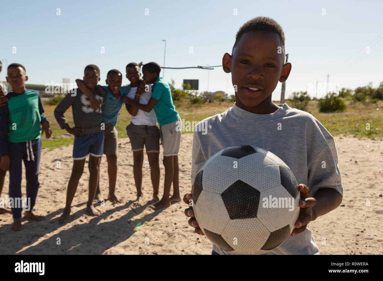 Junge holding Fußball im Boden Stockfoto