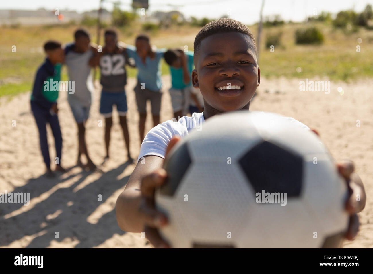 Junge holding Fußball im Boden Stockfoto