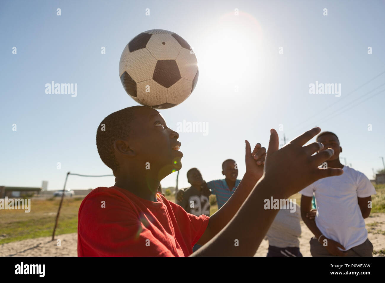 Junge spielt Fußball im Boden Stockfoto