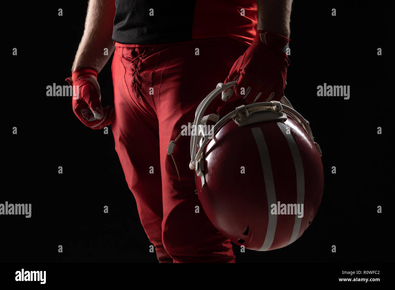 American Football Spieler mit Helm auf schwarzem Hintergrund Stockfoto