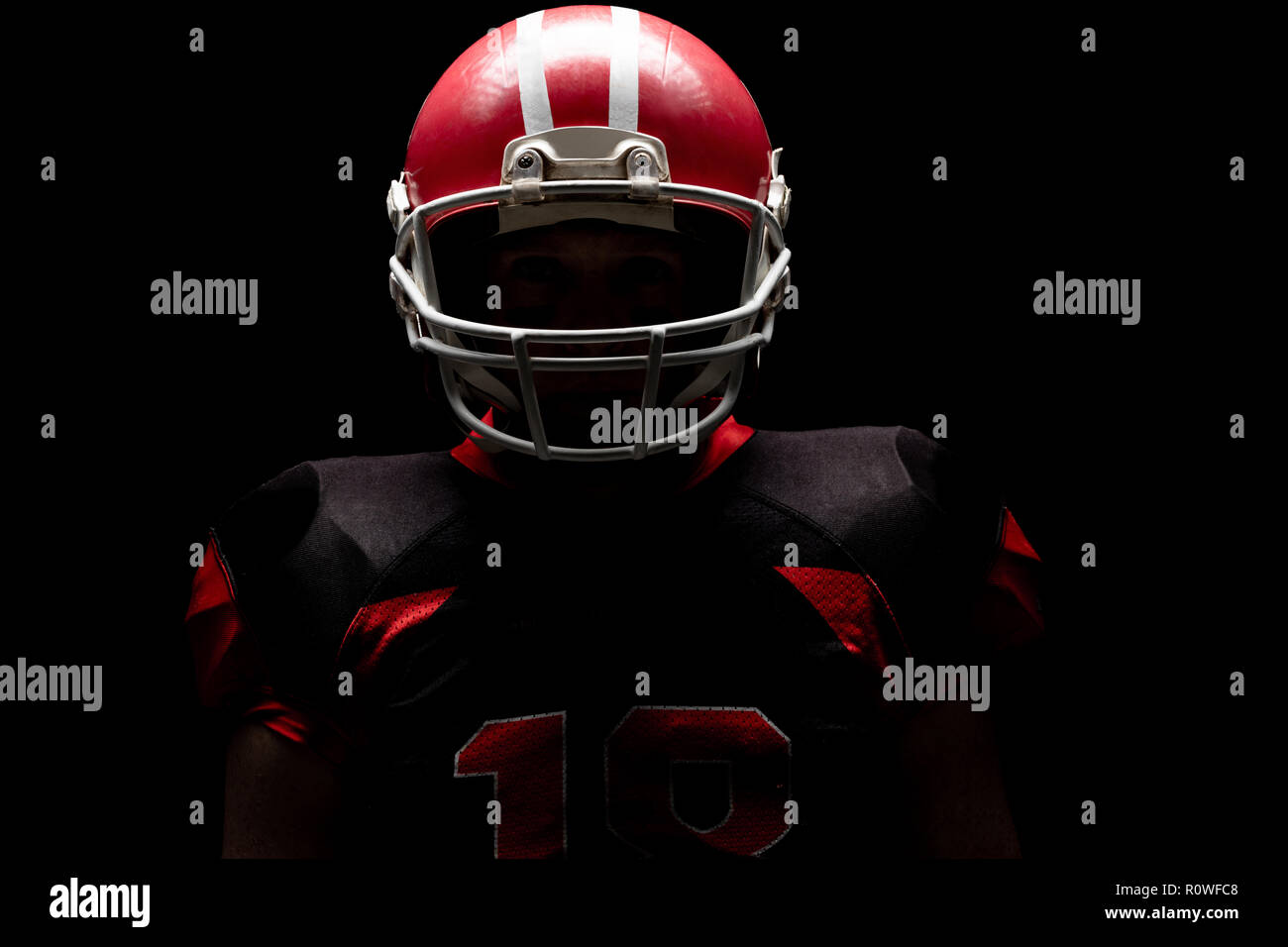 American football player stehend mit Rugby Helm Stockfoto