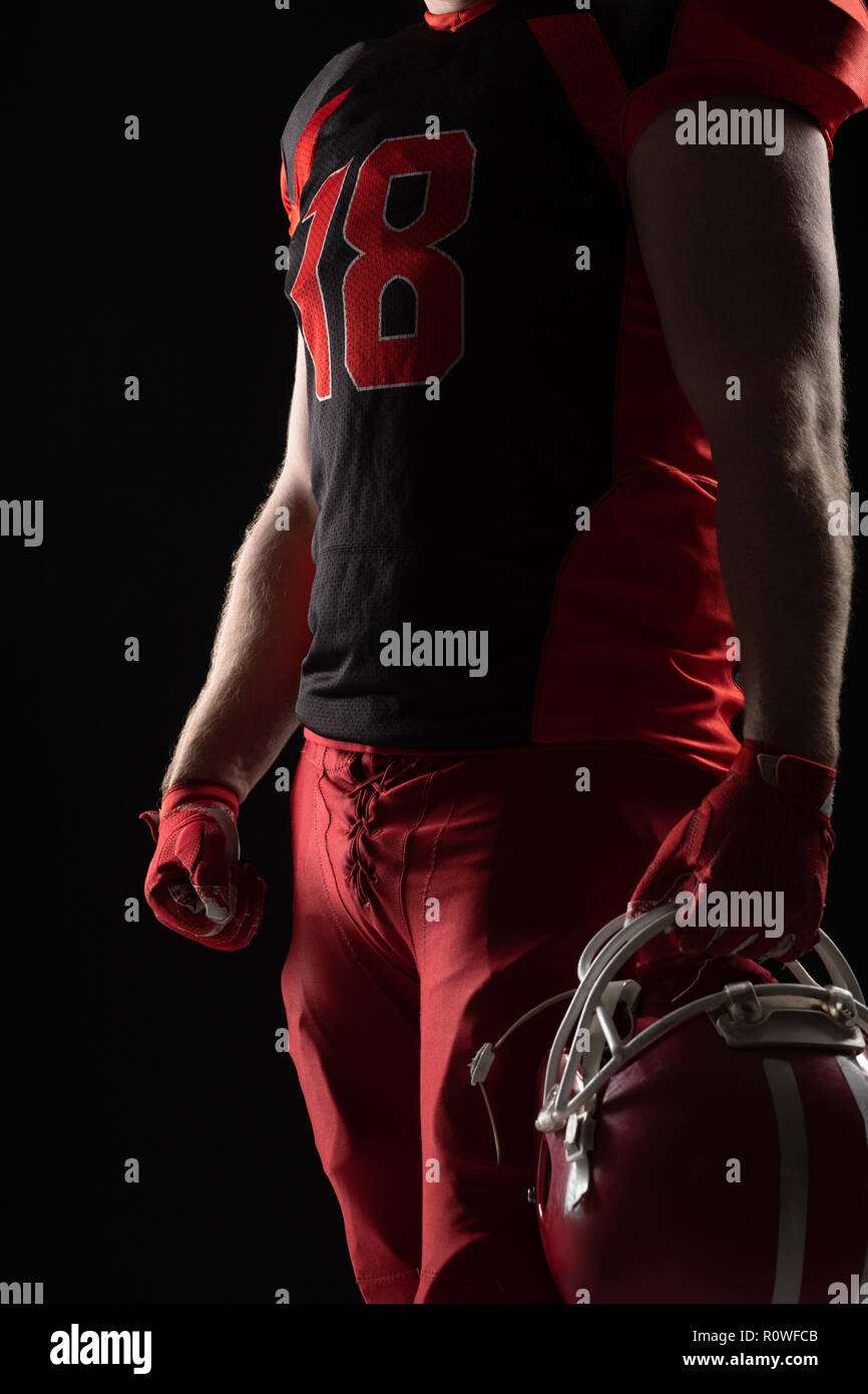 American Football Spieler mit Helm auf schwarzem Hintergrund Stockfoto