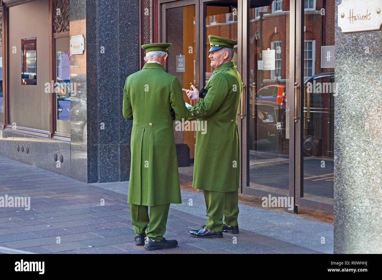 London, Knightsbridge. Uniformierten Portiers ruhen von ihren Pflichten am Eingang zum Kaufhaus Harrods entfernt. Stockfoto