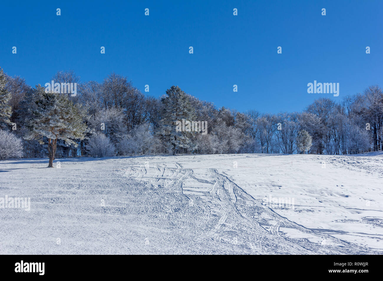 Winterlandschaft mit Schnee Hang zum Schlitten fahren, Schläuche und Motorschlitten in den frühen Morgenstunden Stockfoto