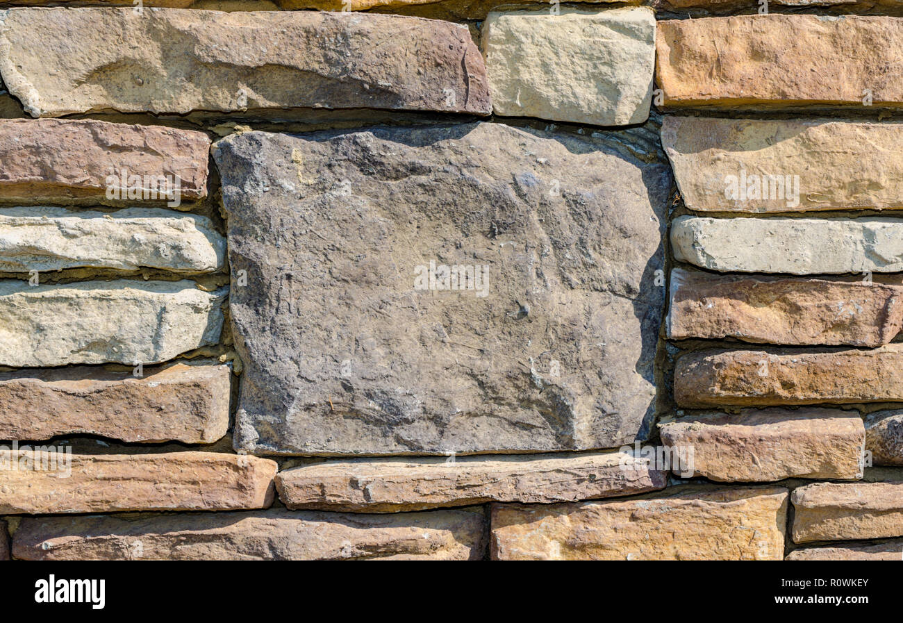Stein Wand mit großen Stein für Kulisse. Ausgezeichnete rustikale Hintergrund Szene mit Platz für Text. Schöne rustikale bunte Textur. Stockfoto