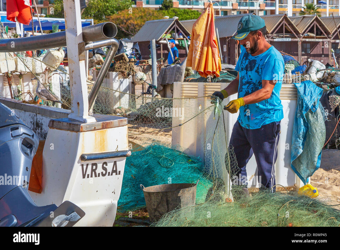 Lokale Fischer seine Fischernetze am Strand von Monte Gordo, Algarve, Portugal tendenziell Stockfoto
