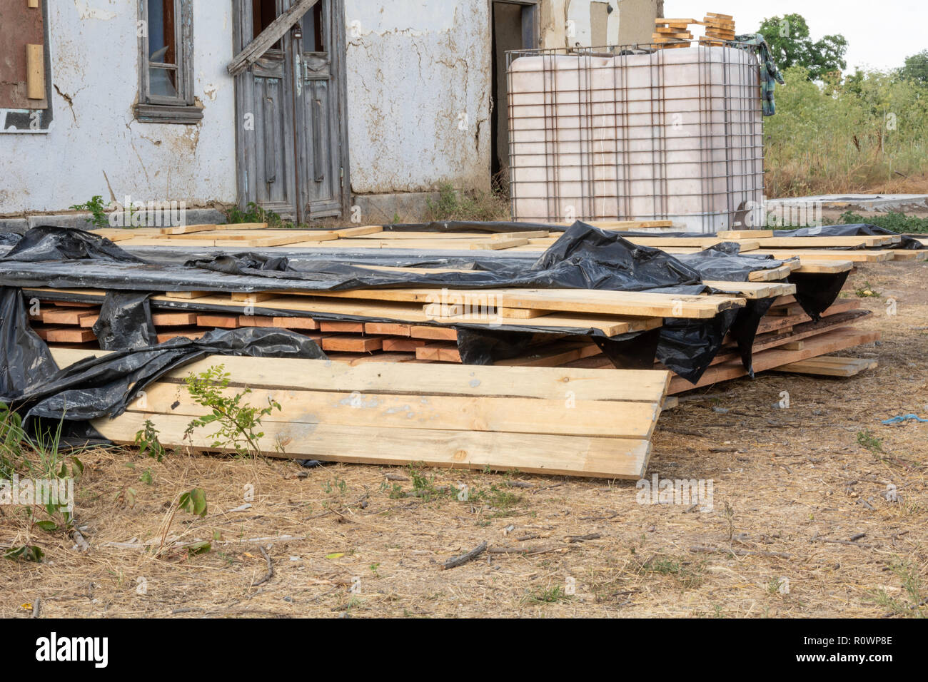Ein Stapel von Kiefer Bretter in einer antiseptischen Lösung getränkt ist auf der Baustelle getrocknet. Baustoffe für den Bau von einem Fachwerkhaus. Stockfoto
