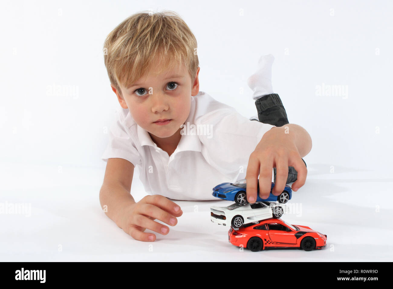 Kind Junge spielt mit Spielzeugautos in einem Studio Stockfoto