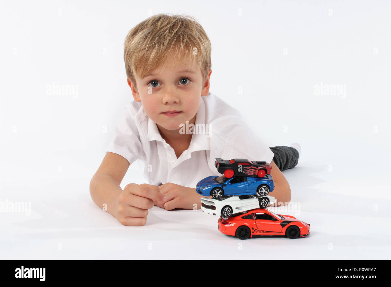 Kind Junge spielt mit Spielzeugautos in einem Studio Stockfoto