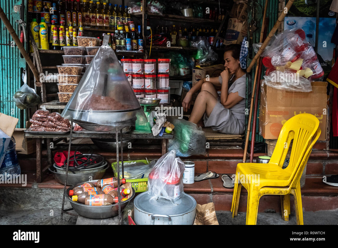 Eine Frau in Gedanken bei ihr Shop in Hanoi, Vietnam verloren. Stockfoto