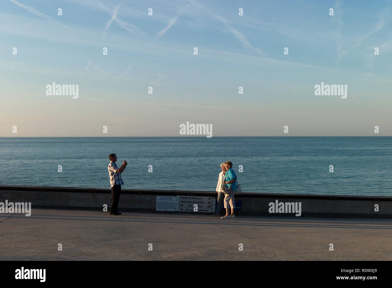 Mann Fotografieren von zwei Frauen, die auf der Promenade, Veules-les-Roses, Normandie, Frankreich Stockfoto