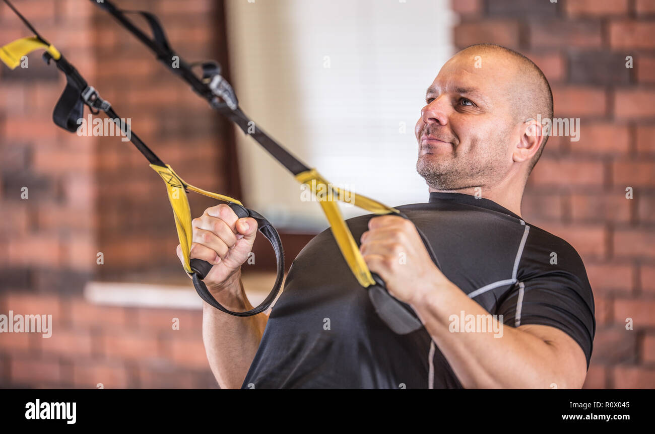 Starker, muskulöser Mann Trainieren mit trx Einrichtungen im Fitnessraum oder Training Center. Stockfoto