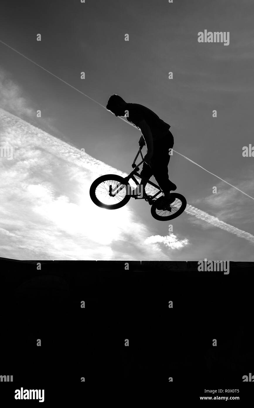 Ein BMX-rider an der Plaza, Central forest park in Stoke on Trent Reiten hoch und dabei Stunts in Silhouette als die Sonne untergeht Stockfoto