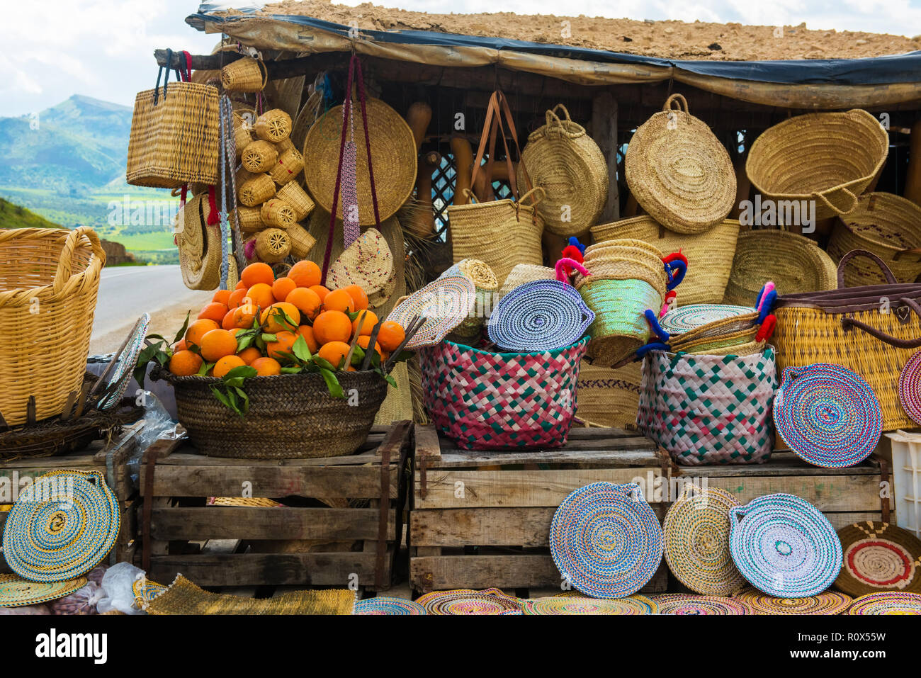 Handwerk wicker Hüte, Orangen und andere Souvenirs in Marokko Markt Stockfoto