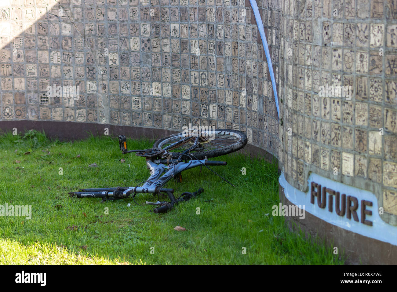 Ein verlassenes Fahrrad fehlt das Vorderrad vor der "Zukunft" des Millenium Mauer Denkmal in Chippenham gedumpten Stockfoto