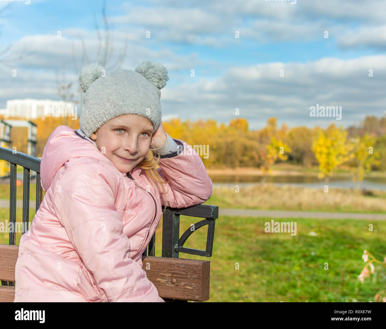 Mellow Herbst. Portrait der netten kleinen Mädchen auf einer Bank. Kopieren Sie Platz für Text. Stockfoto