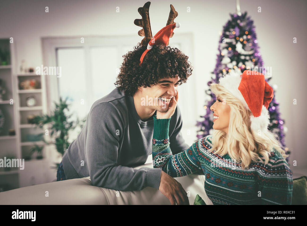 Paar in der gemütlichen warmen Pullover auf ein Weihnachten - Silvester, lächelnd und Spaß mit einander. Stockfoto
