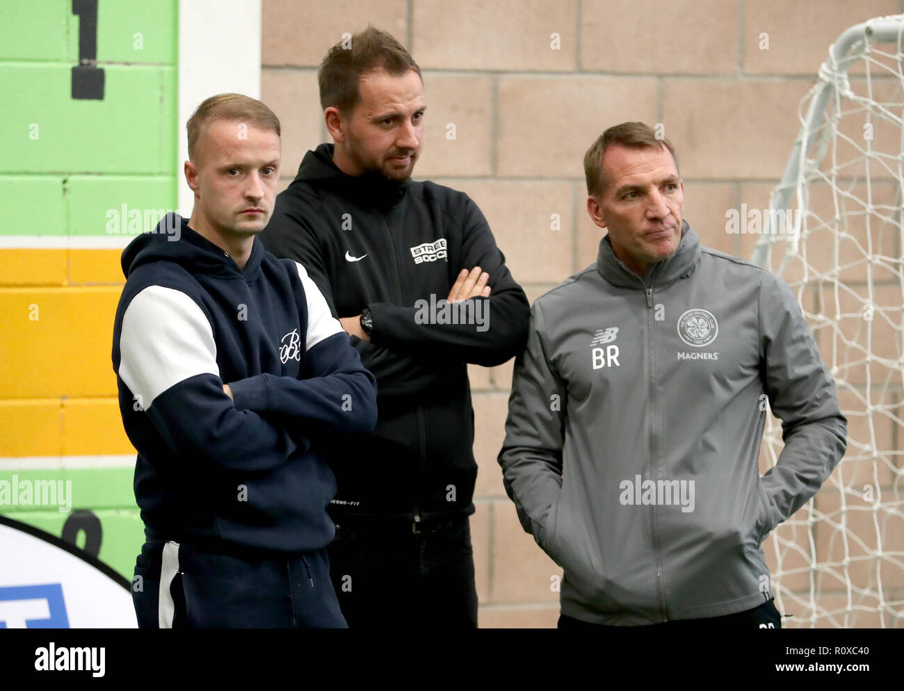 Celtic's Leigh Griffiths (links) und Manager Brendan Rodgers (rechts) mit Street Soccer Gründer und CEO David Duke (Mitte) sehen die Männer und Frauen Street Soccer Teams während einer speziellen Schulung an Lennoxtown, Glasgow. Stockfoto