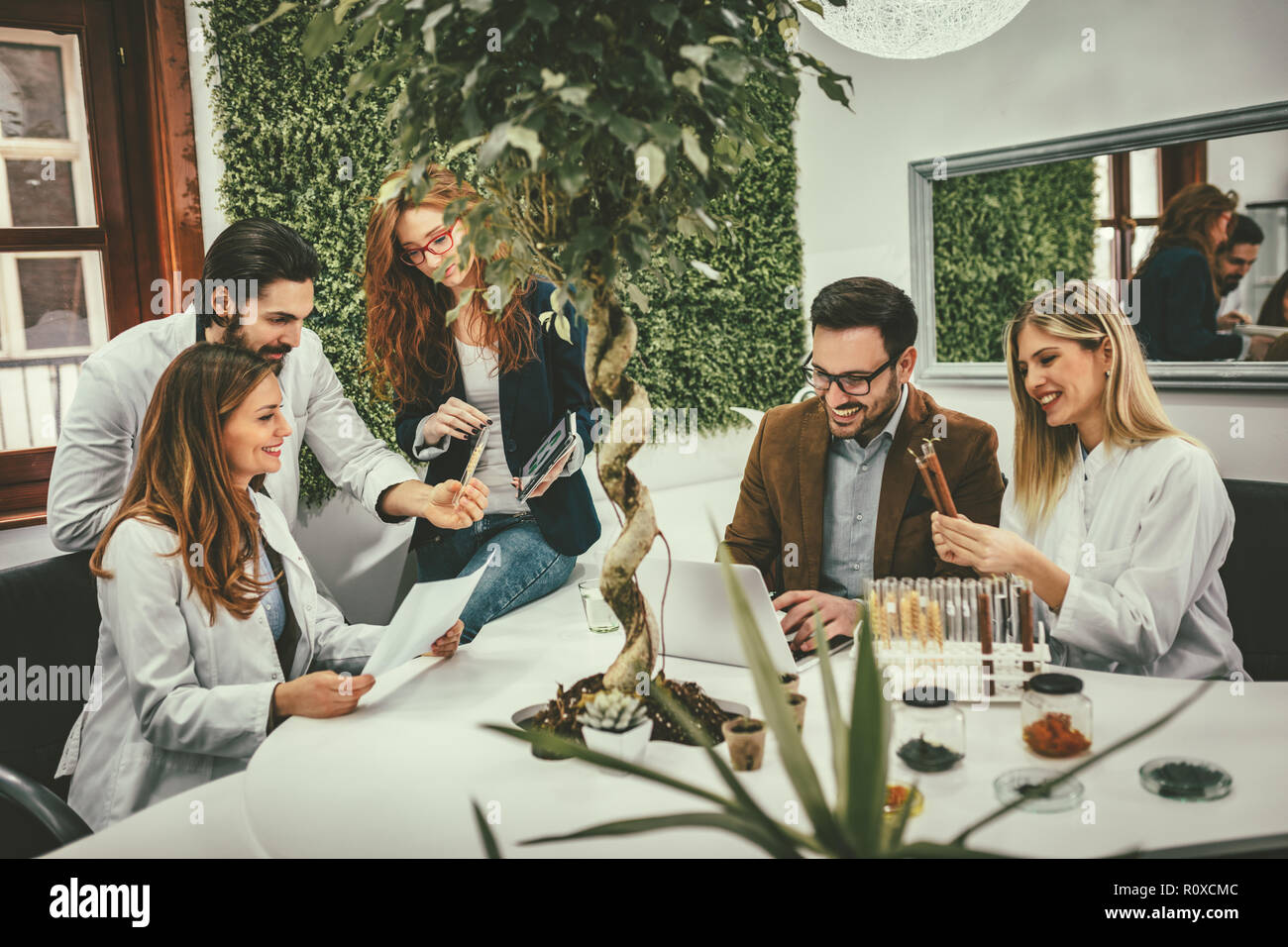 Clevere progressive junge Ingenieure arbeiten an digitalen Tablet auf einer ökologischen Bauvorhaben im Büro, reden über einige grüne Projekt. Stockfoto