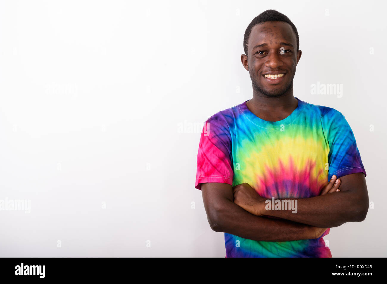 Studio shot von jungen schwarzen afrikanischen Mann lächelnd mit gekreuzten Armen Stockfoto