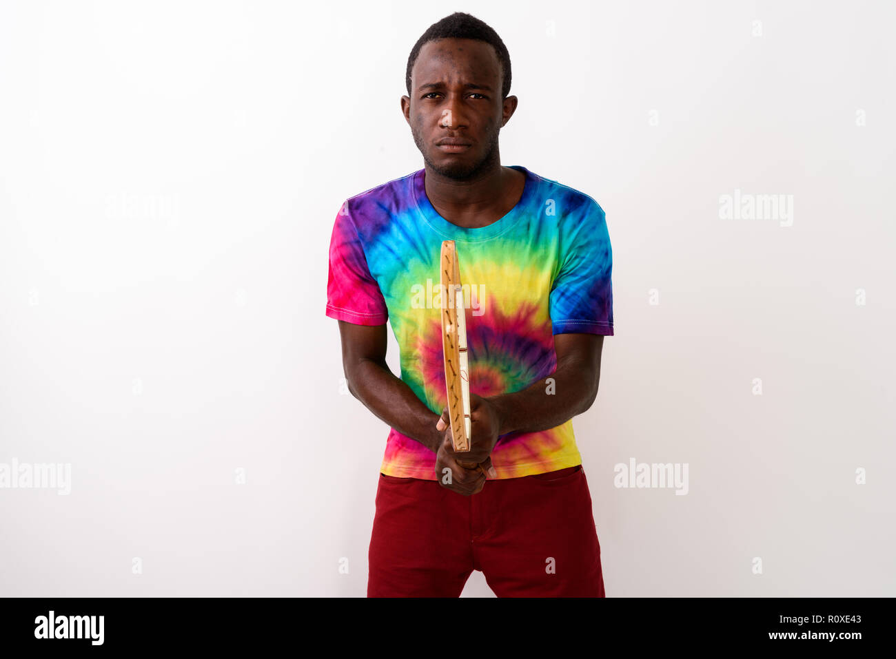 Studio shot von jungen schwarzen afrikanischen Mann Tennis Spieler gegen whi Stockfoto