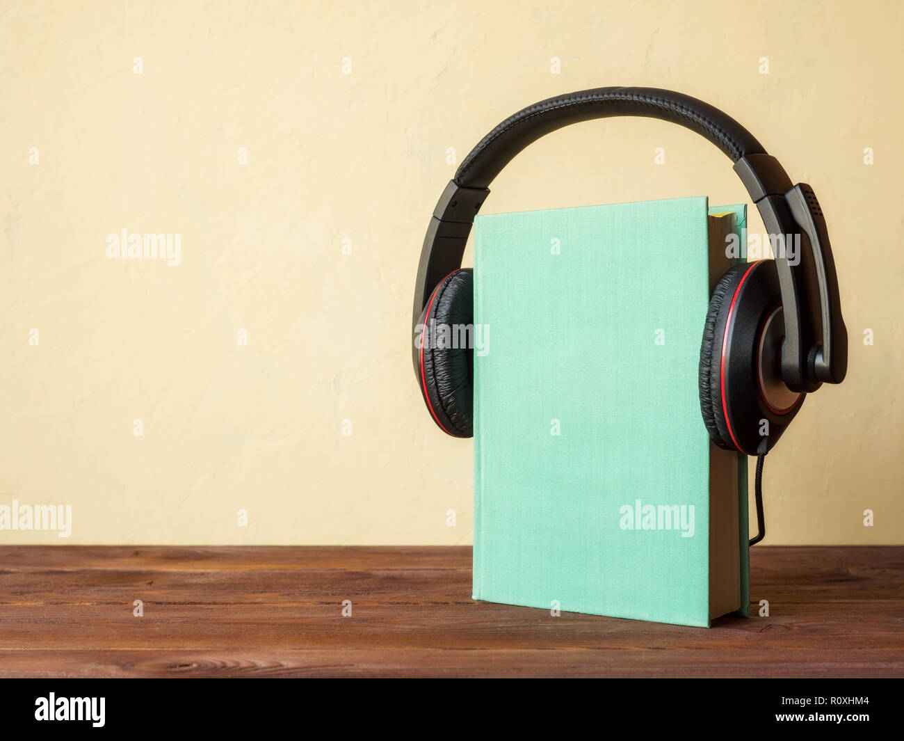 Konzept der Hörbuch. Buch auf dem Holztisch mit Kopfhörern auf Sie Stockfoto