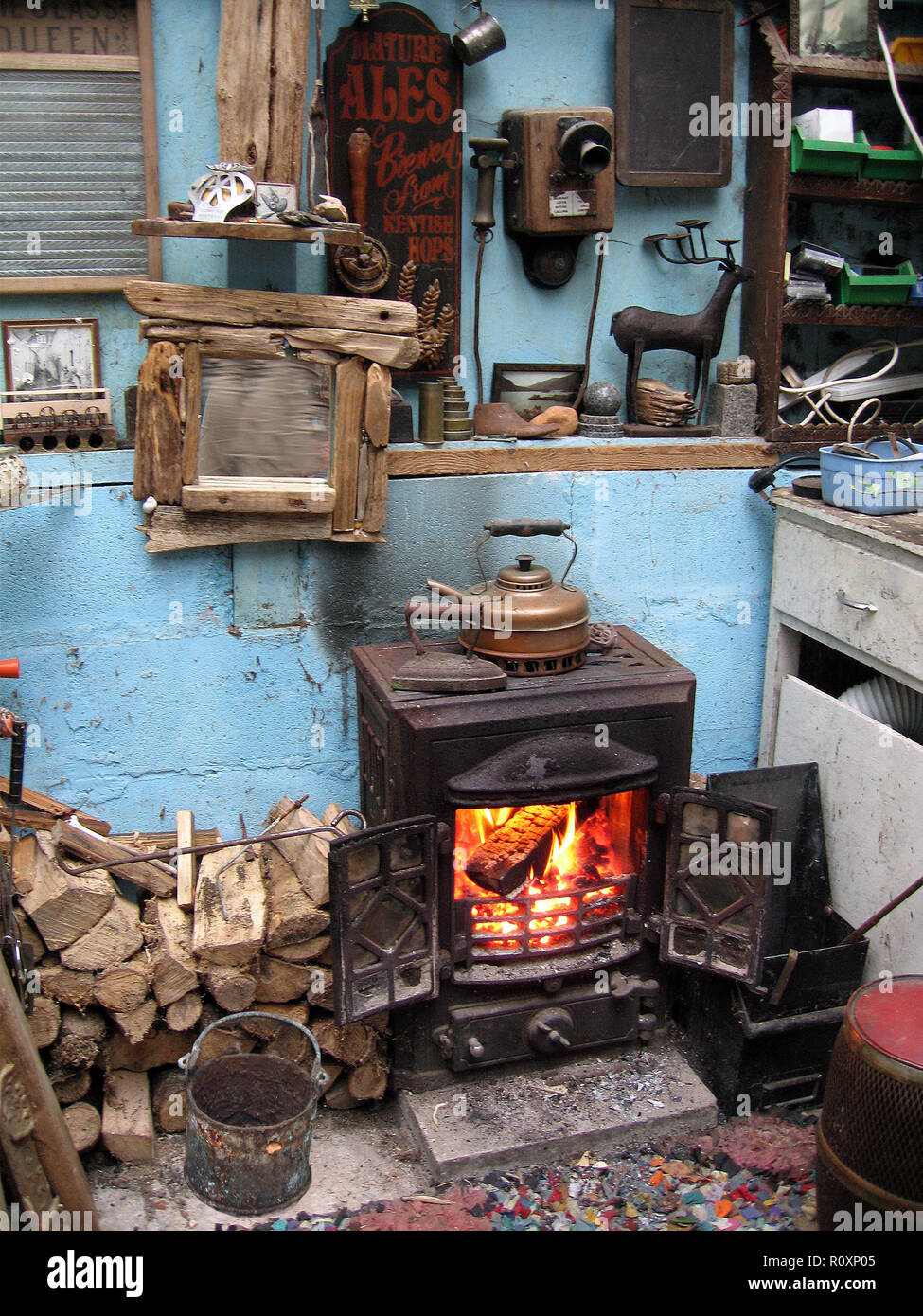 Interieur einer gemütlichen mancave in einem Gartenhaus mit brennendem Ofen. Kirckudbright, Schottland Stockfoto