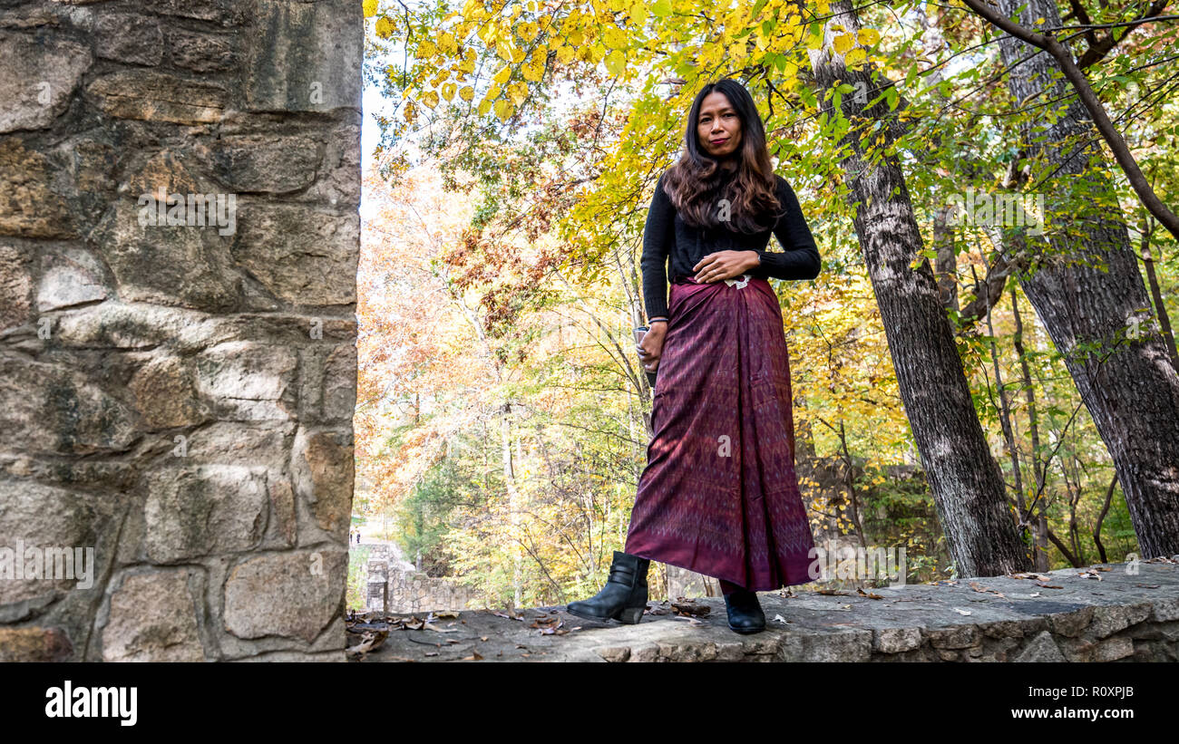 Frau, die an der Wand aus Stein im Amphitheater von sarong Stockfoto