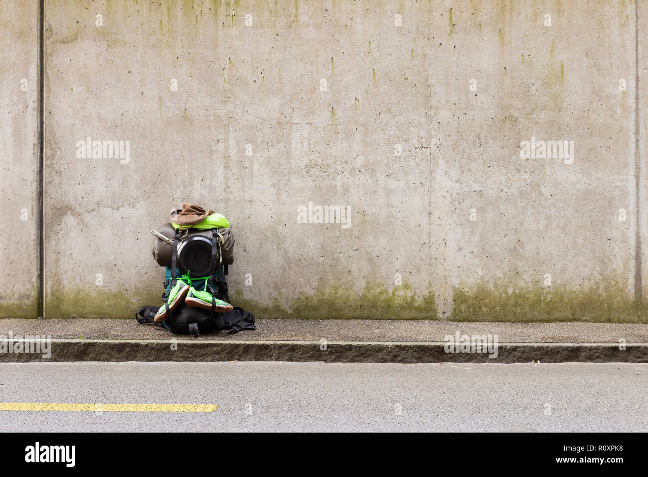 Wanderrucksack mit grünem Tuch, Bratpfanne, Schlafsack, leder hut und grüne  Schuhe stehen auf einer Straße vor einer grauen Wand Stockfotografie - Alamy