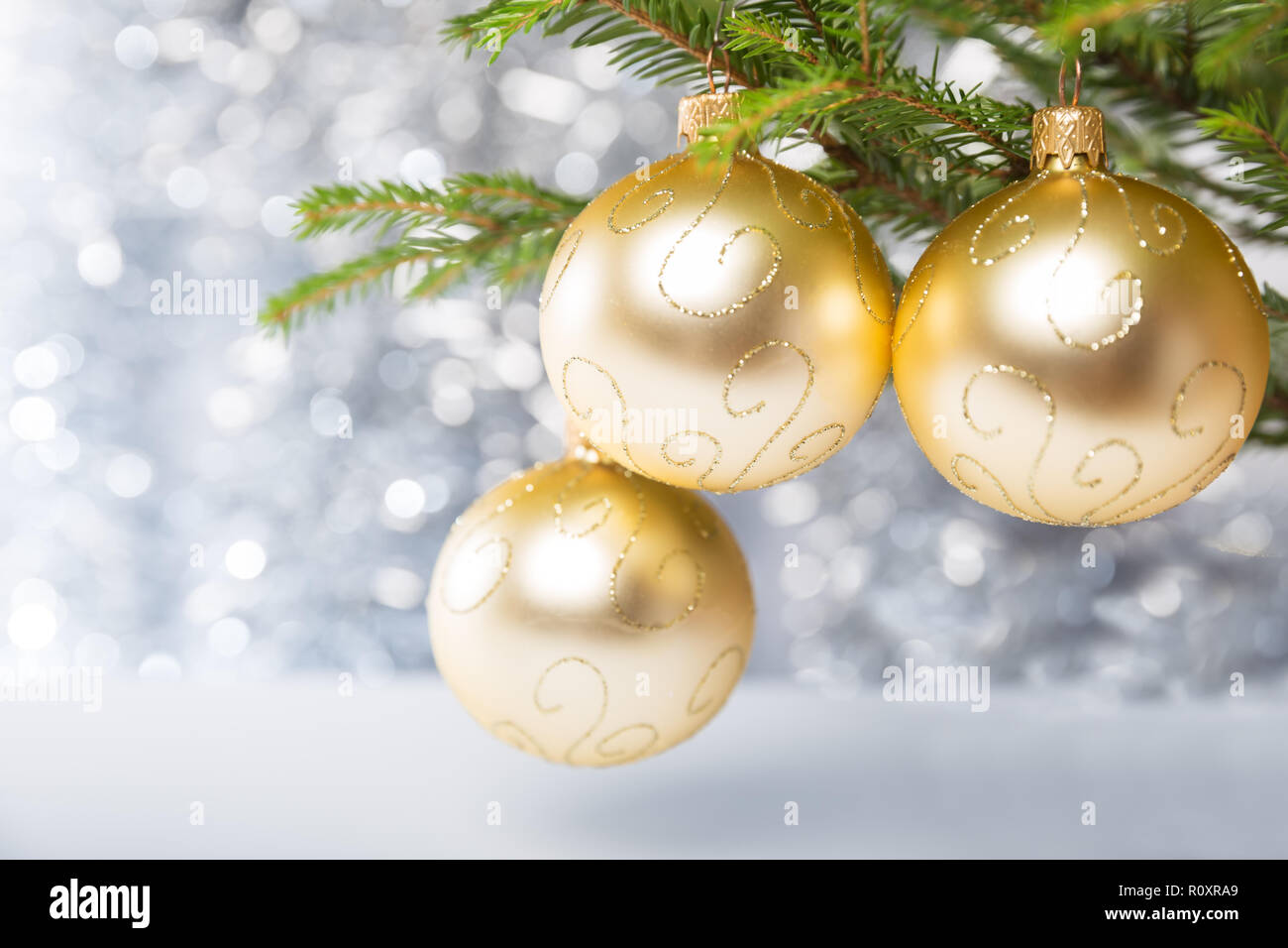 Weihnachtsschmuck, drei goldene Kugeln am Weihnachtsbaum Stockfoto
