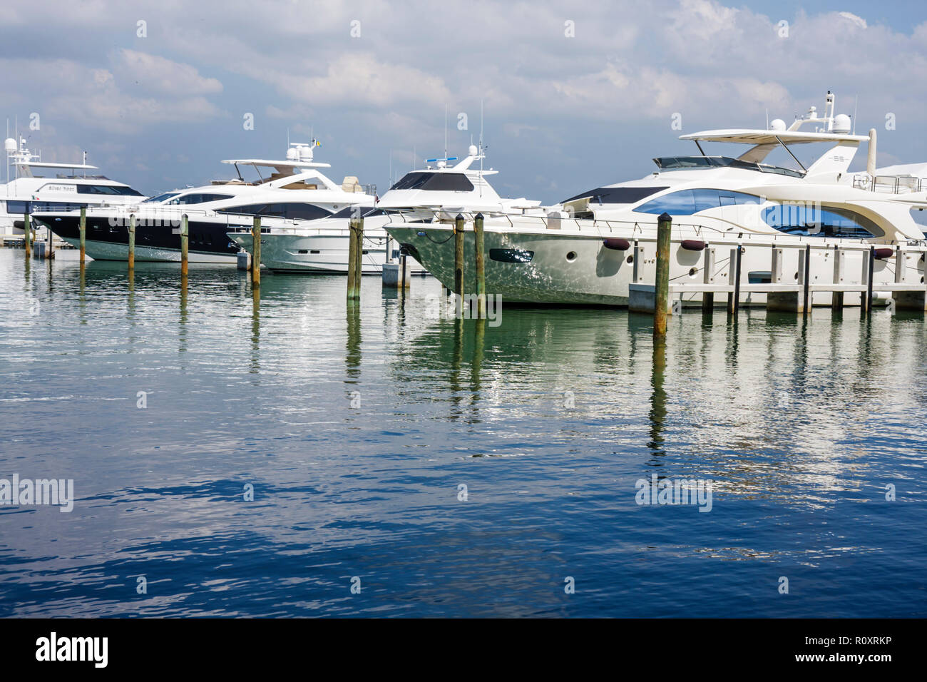 Miami Beach Florida, Biscayne Bay Water, Yachthafen, Luxus, Yacht, Flybridge, Wasserfahrzeuge, High-End, Erholung, Freizeit, Bootfahren, angedockt, Pilings, Reflexion, Besucher Stockfoto
