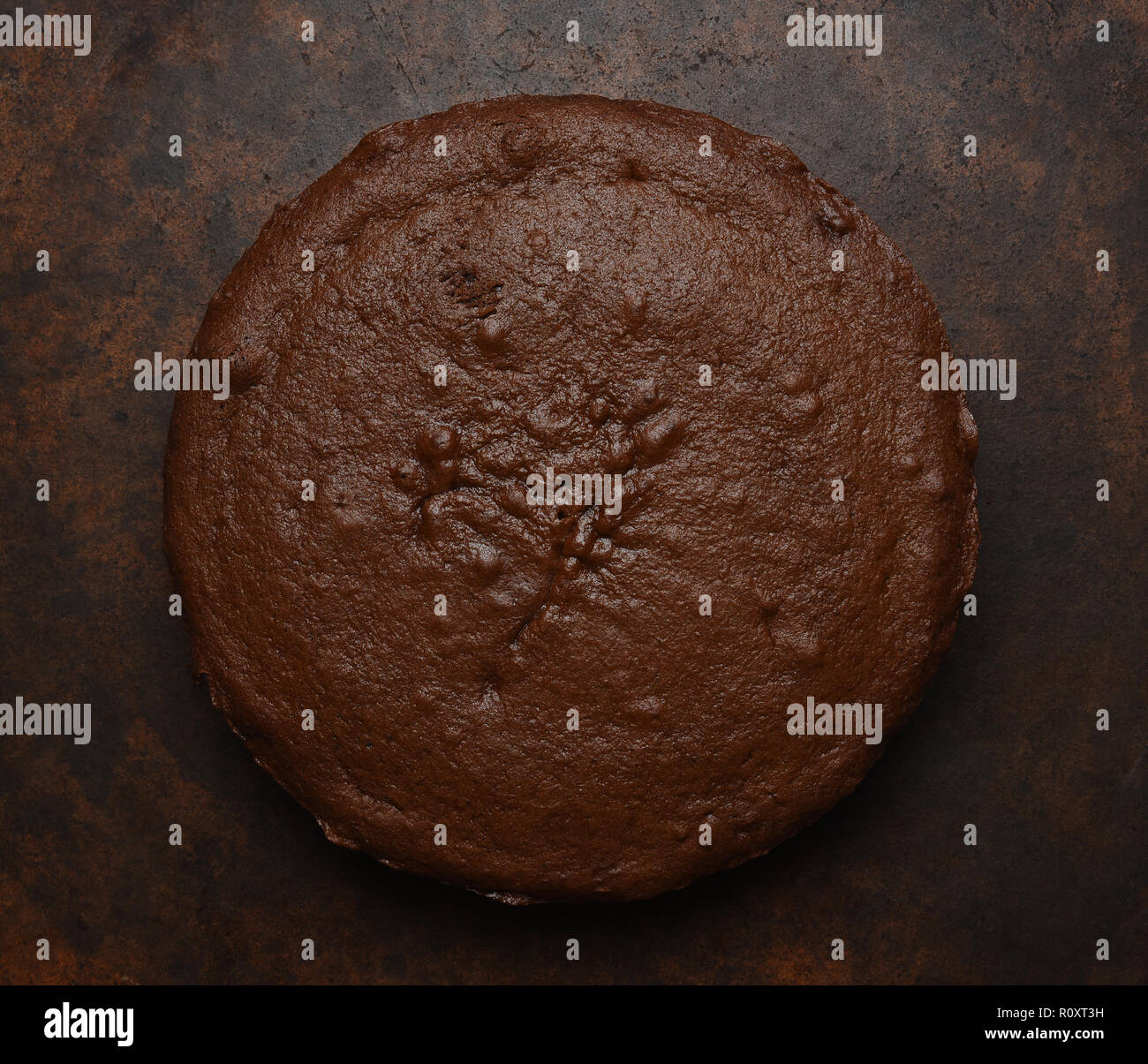 Flach von einer einzigen Schicht Schokolade Kuchen auf einem dunklen braun gesprenkelter Hintergrund. Stockfoto