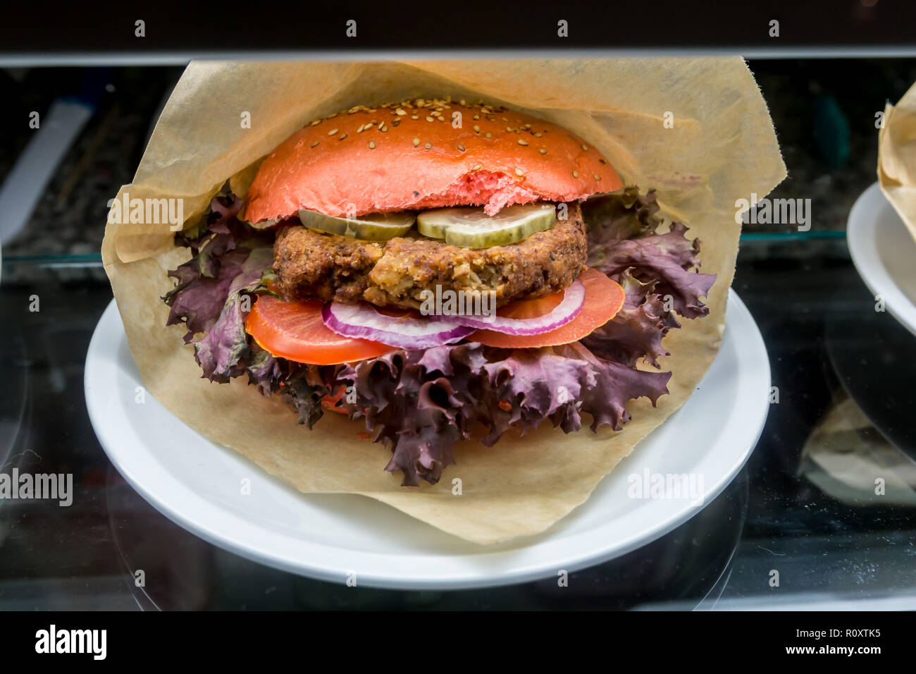 Tofu Hamburger mit roten Brötchen auf dem Teller Stockfoto