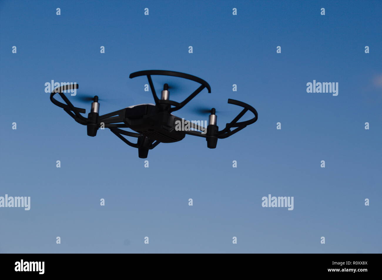 Flying drone howering im Himmel Stockfoto