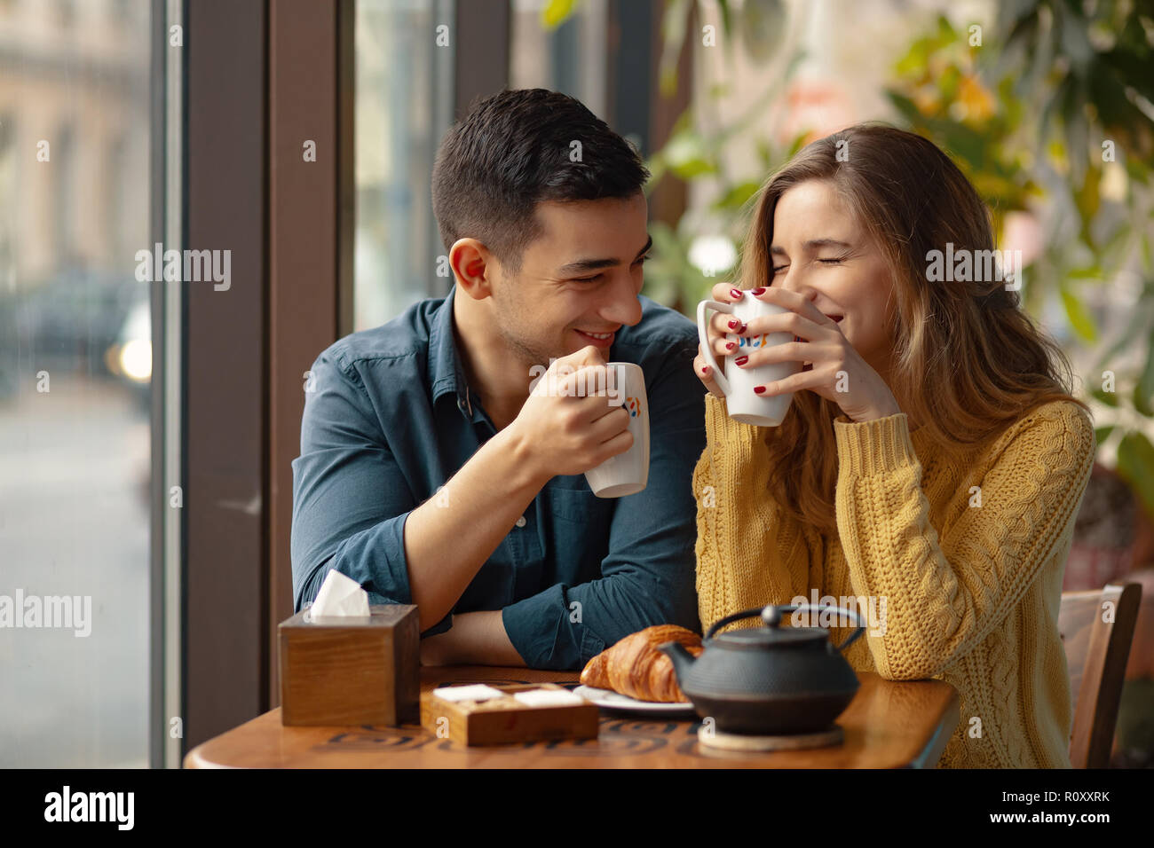 Junge Attraktive Paar Auf Datum Im Coffee Shop In Der Liebe Des Mannes Junge Attraktive Paar Auf Datum Im Coffee Shop In Der Liebe Des Mannes Und Der Frau In Einem Caf Sitzen Kaffee Trinken R0xxrk