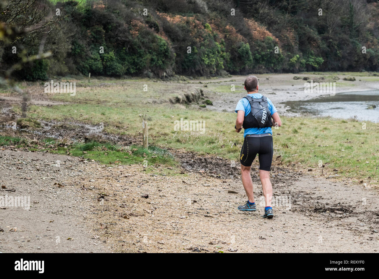 Eine Person, die entlang dem Fluss Gannel bei Ebbe in Newquay Cornwall läuft. Stockfoto