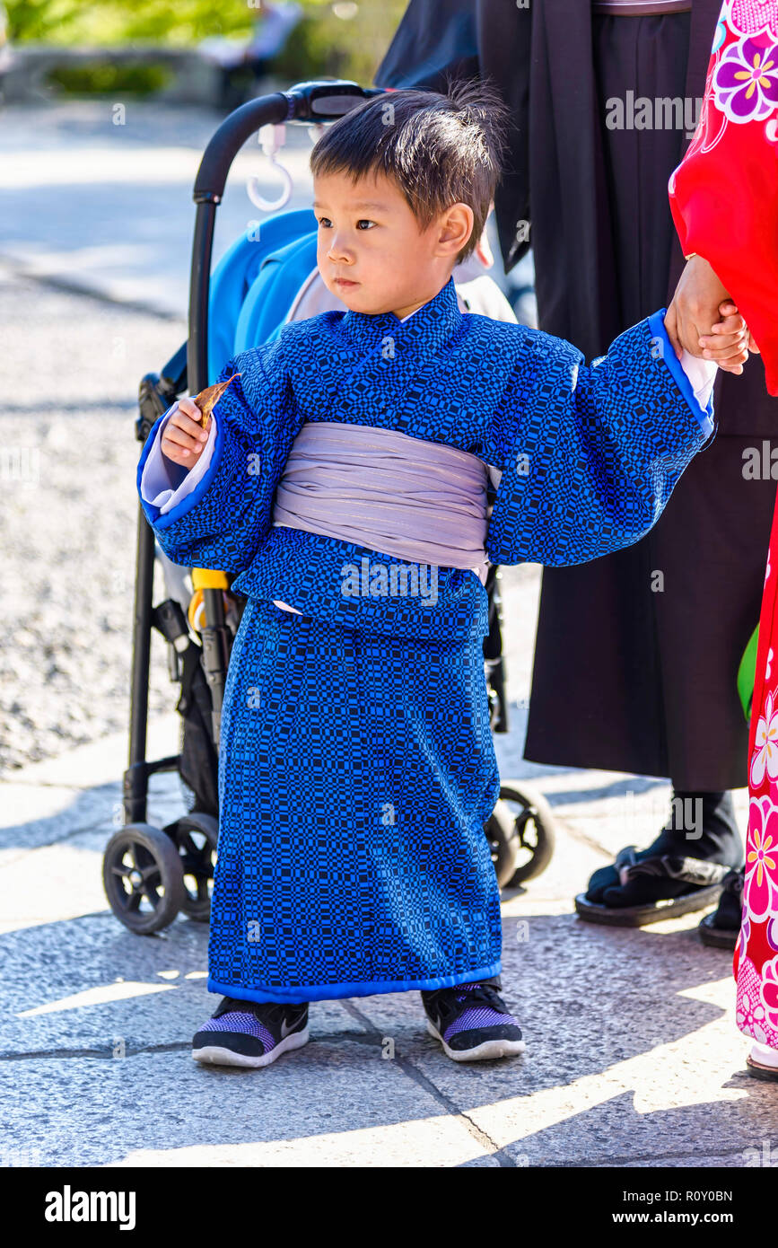 Kyoto, Japan - 23. April 2014: Kleine asiatische Kind mit einem blauen Kimono. Der Kimono ist ein traditionelles japanisches Gewand Stockfoto