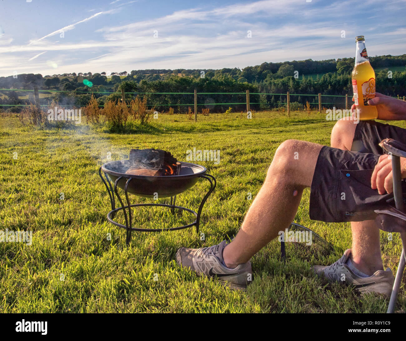 Kaukasische Mann erholsamen Urlaub auf einem Campingplatz seinen Abend verbringen genießen Sie die Aussicht vom Lagerfeuer im Vereinigten Königreich. Stockfoto