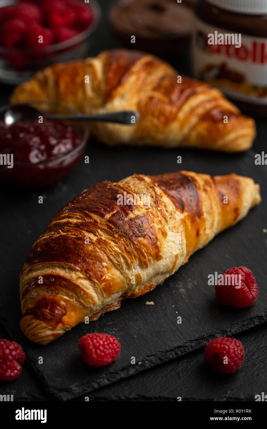 Croissants umgeben mit Himbeeren, Himbeer Marmelade und Nutella Stockfoto