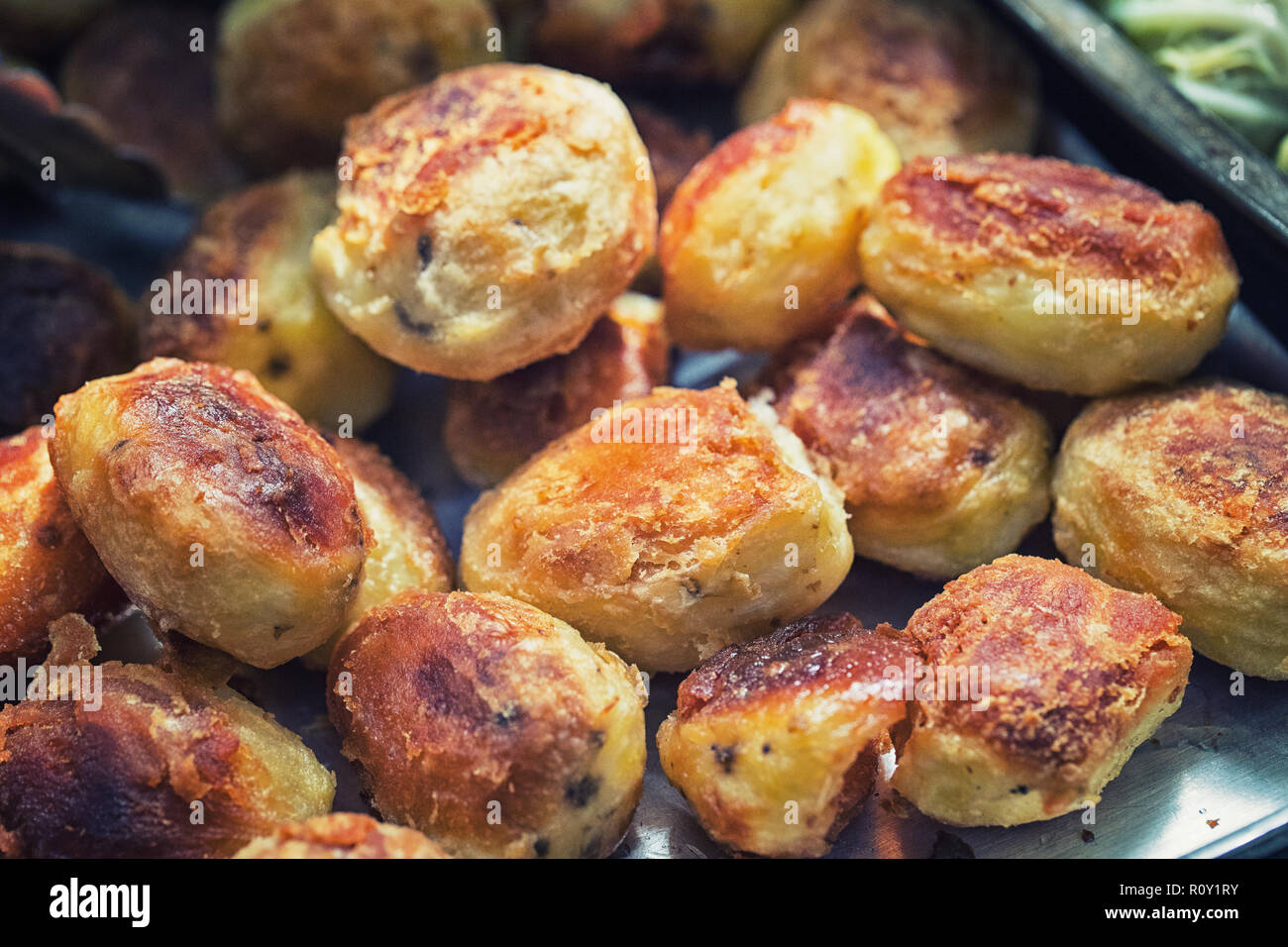 Ein frisch zubereitetes, knusprig und knackig sein, ein Tablett mit gerösteten Kartoffeln eine Britische traditionellen Roastbeef Sonntag Mittagessen Abendessen Mahlzeit zu begleiten. Stockfoto