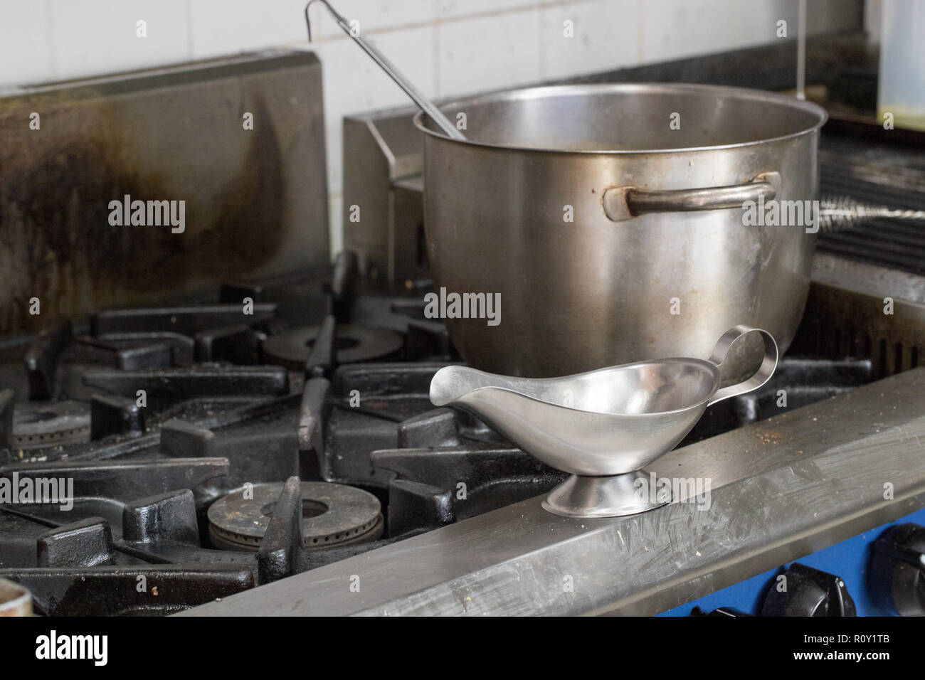 Leere Edelstahl Soße Kanne und Topf auf einem Herd in einem kommerziellen Küche bereit, die von der Koch oder Köchin verwendet werden. Stockfoto