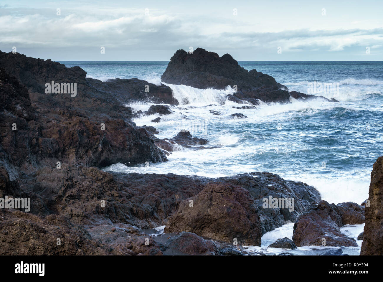 Meereslandschaft mit Wellen, die auf den Felsen in Seixal, Madeira Stockfoto