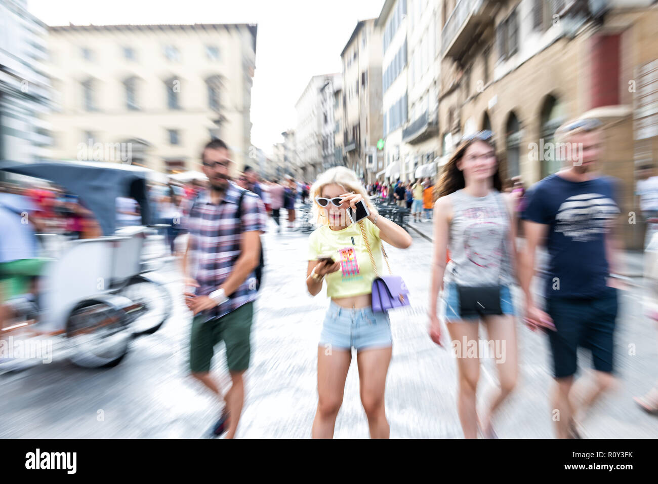 Florenz, Italien - 30 August 2018: Zoom platzen, und Zoomen Auswirkungen auf Menge, Leute, Touristen, blonde Frau stehen, zu Handy, Smartphone suchen, Halten Stockfoto