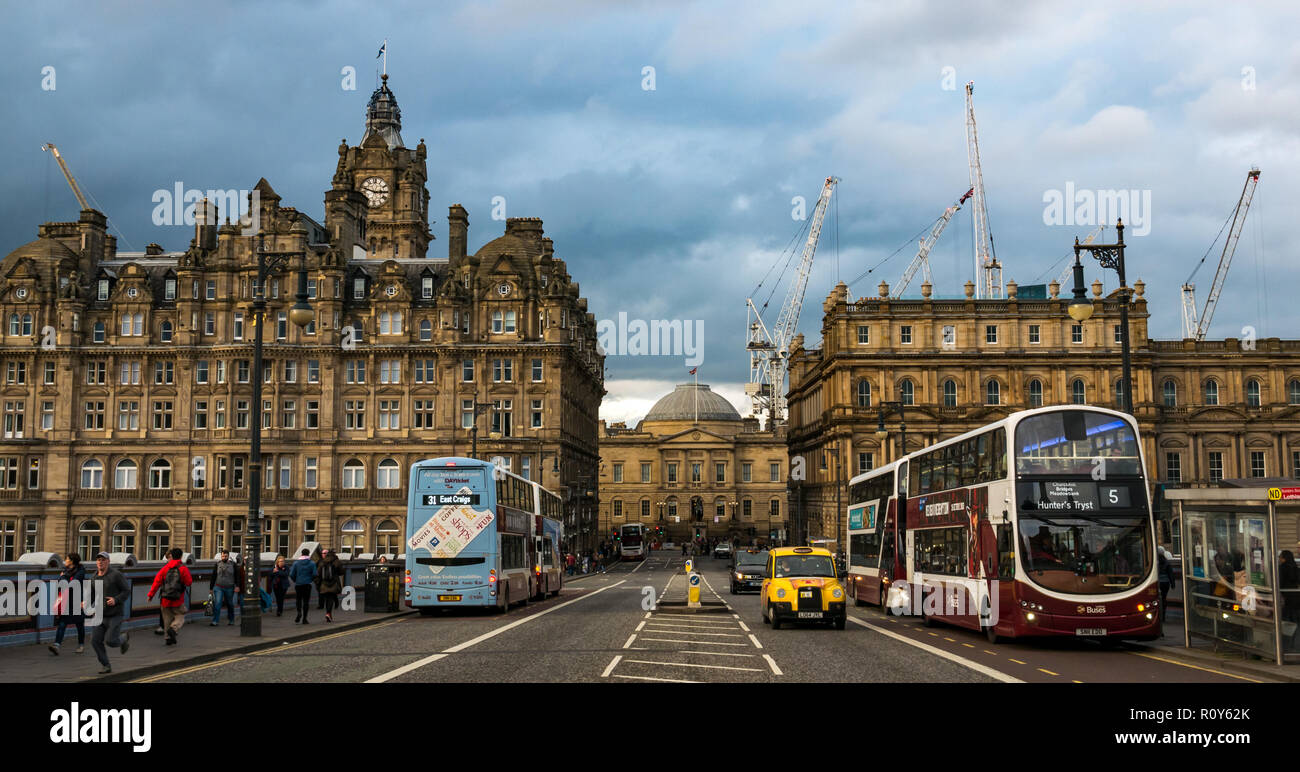 Edinburgh, Schottland, Vereinigtes Königreich, 7. November 2018. UK Wetter: Dunkle Wolken über der Innenstadt Gebäude sammeln. Das Balmoral Hotel Uhrturm auf der North Bridge mit Lothian Buses ist besetzt mit Fußgängern und Baukräne in den neuen St James Entwicklung überragt die Dachlinie Stockfoto