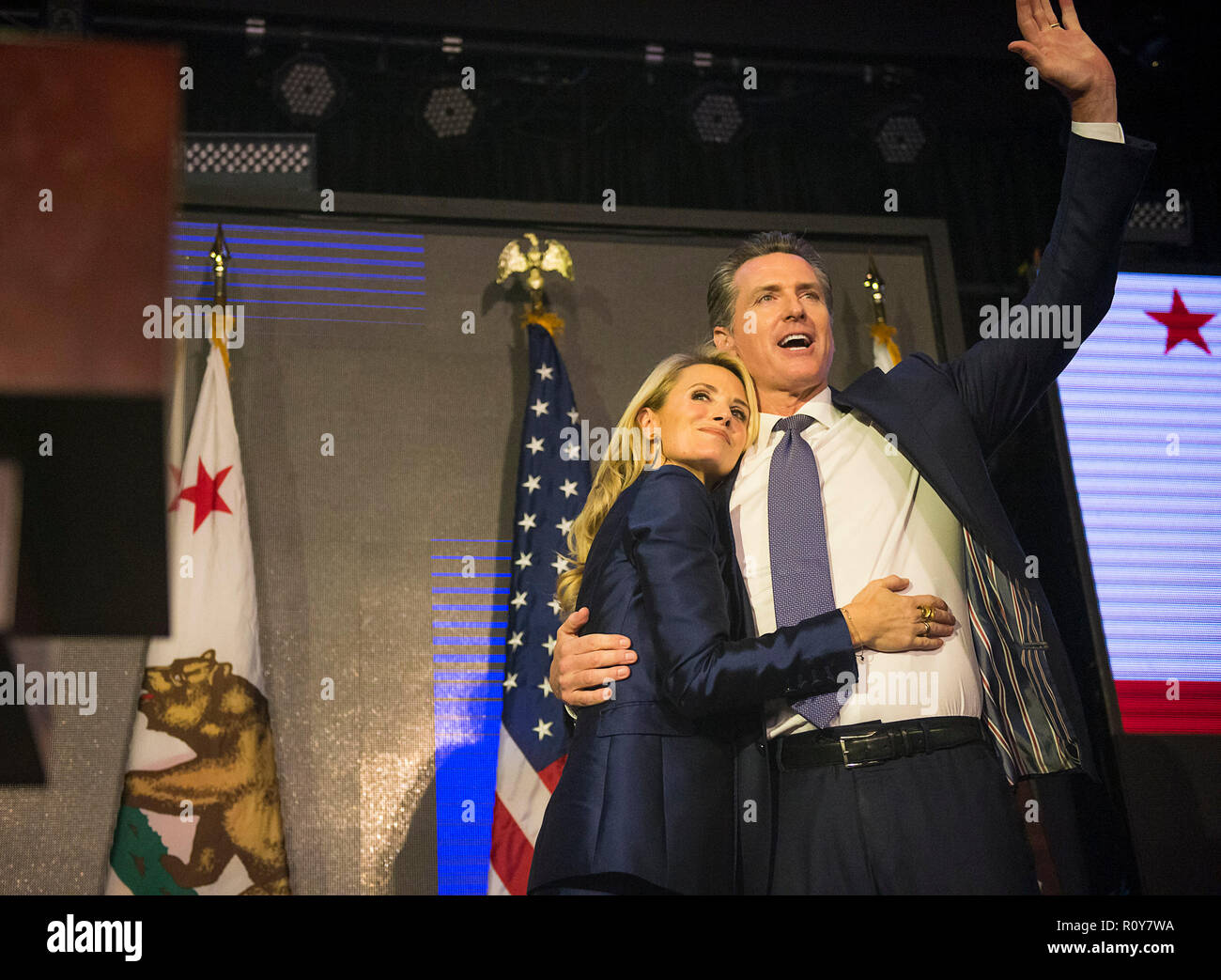 Los Angeles, Kalifornien, USA. 6 Nov, 2018. Der demokratische Kandidat für Calif Gouverneur Gavin Newsom feiert seinen Sieg mit einer Umarmung Form seiner Frau Jennifer Siebel NEWSOM während seiner Kampagne Partei an der Börse in Los Angeles. Credit: Paul Kitagaki jr./ZUMA Draht/Alamy leben Nachrichten Stockfoto