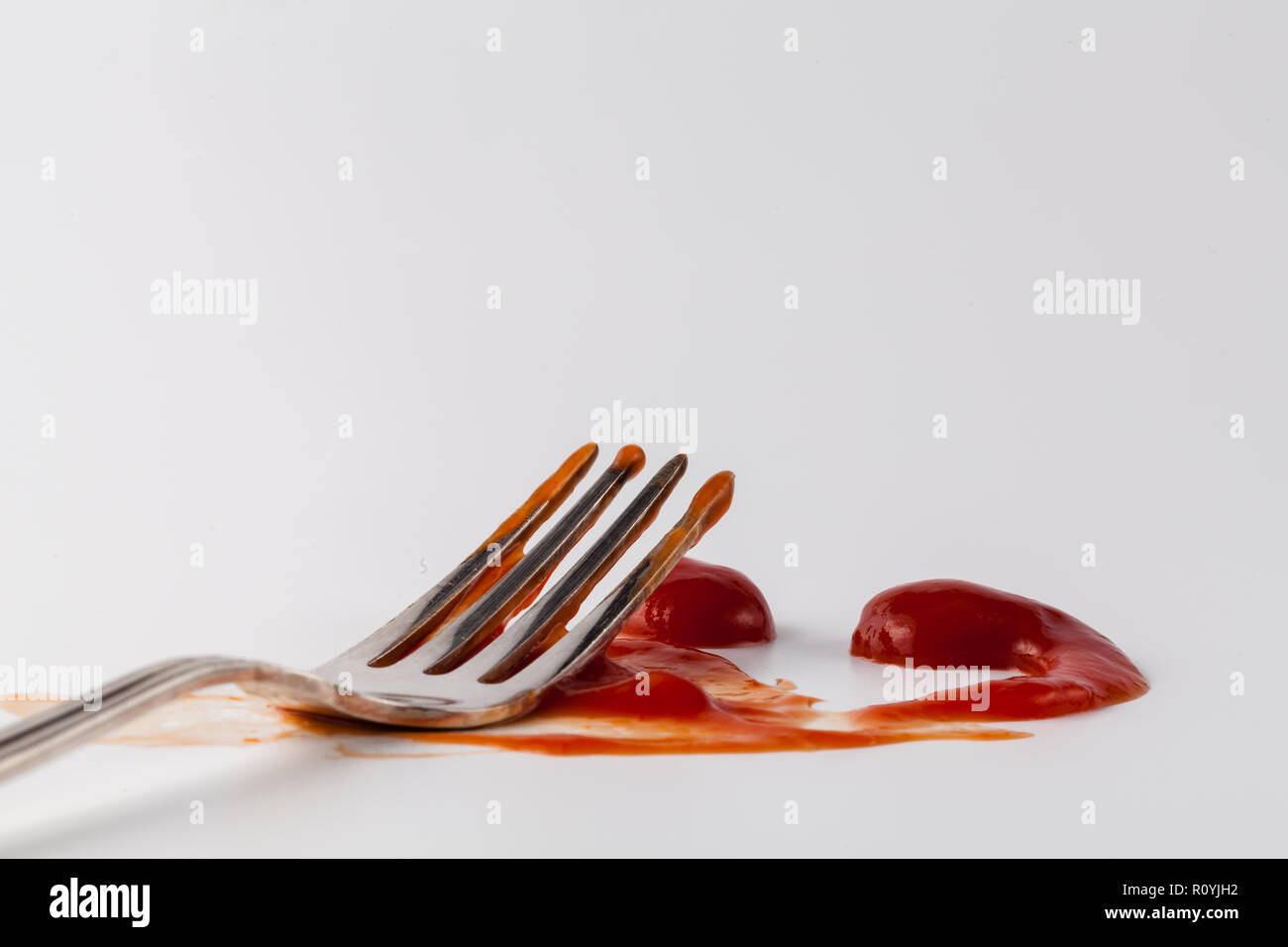 Red ketchup spritzt auf weißem Hintergrund, Tomate, reine Textur mit Gabel Stockfoto